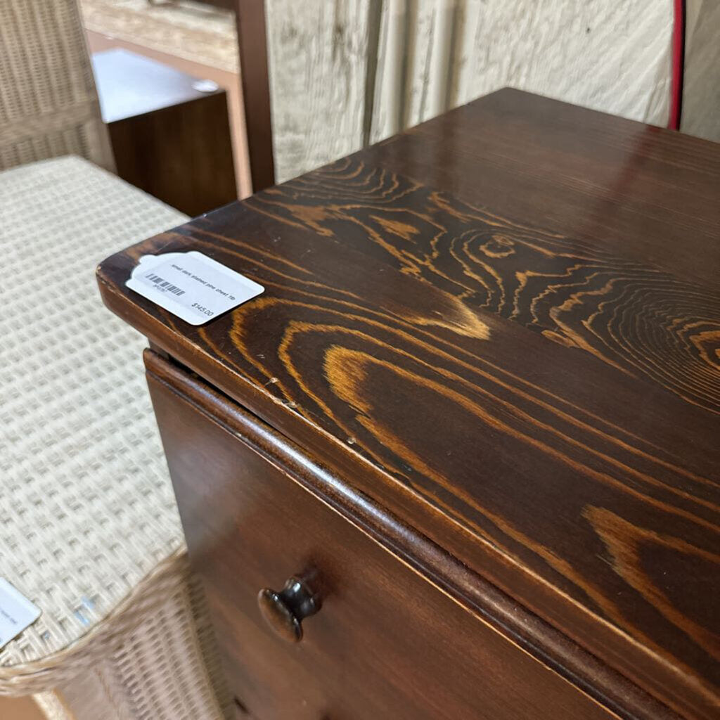 Wooden drawer with a visible brand label on a textured surface