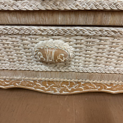 Decorative woven box with intricate patterns and a central emblem on a wooden surface.