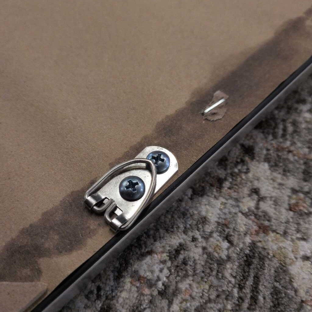 Close-up of a metal bracket with screws on a textured surface