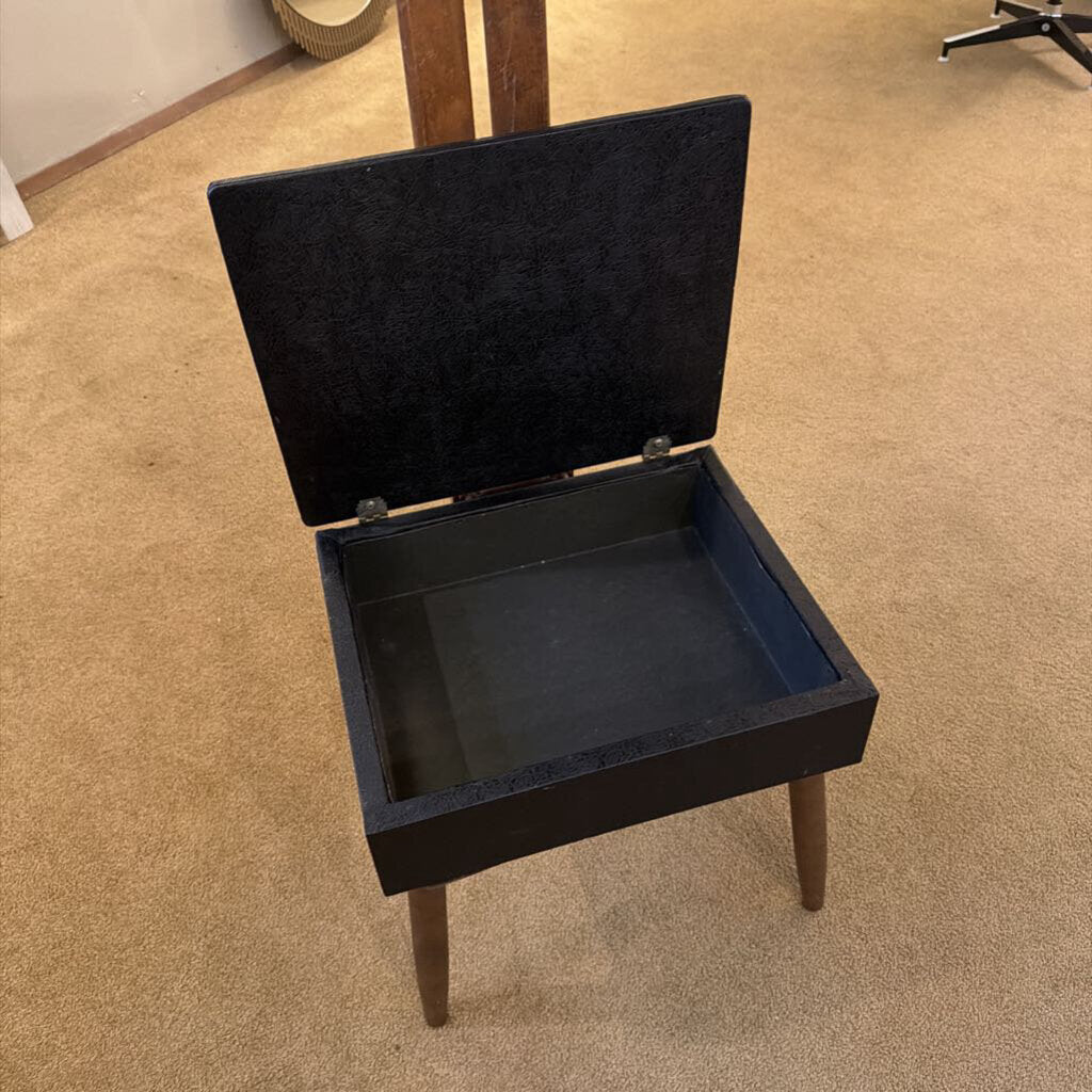 Black wooden box with a lid on a beige carpeted floor