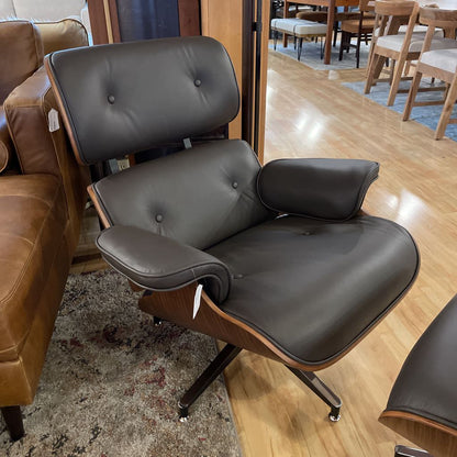Brown leather chair with wooden armrests on a wooden floor.