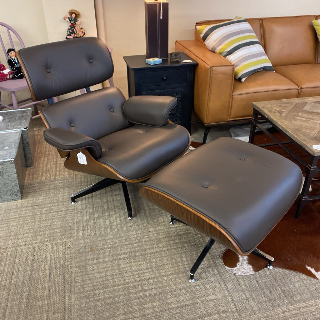 Eames-style lounge chair and ottoman in a room with a brown couch and coffee table.
