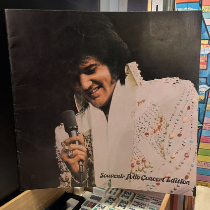 Elvis Presley album cover with a smiling Elvis holding a microphone, featuring colorful embellishments.