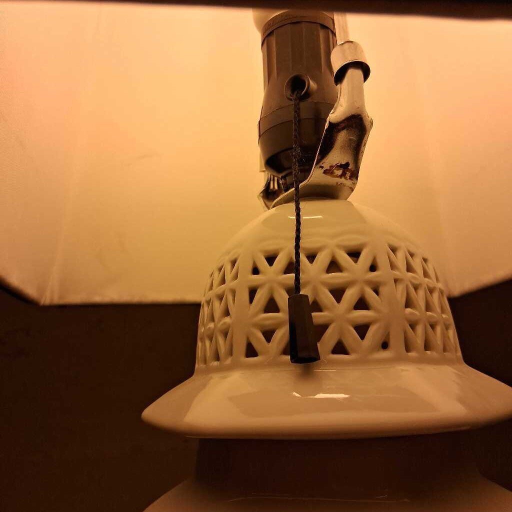 Close-up of a ceramic lamp with a textured design and visible wiring.