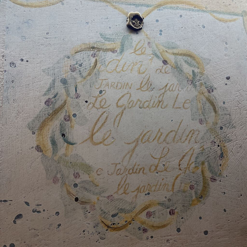 close up of french script mirror writing that says "le jardin"
