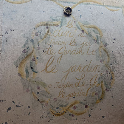 close up of french script mirror writing that says "le jardin"