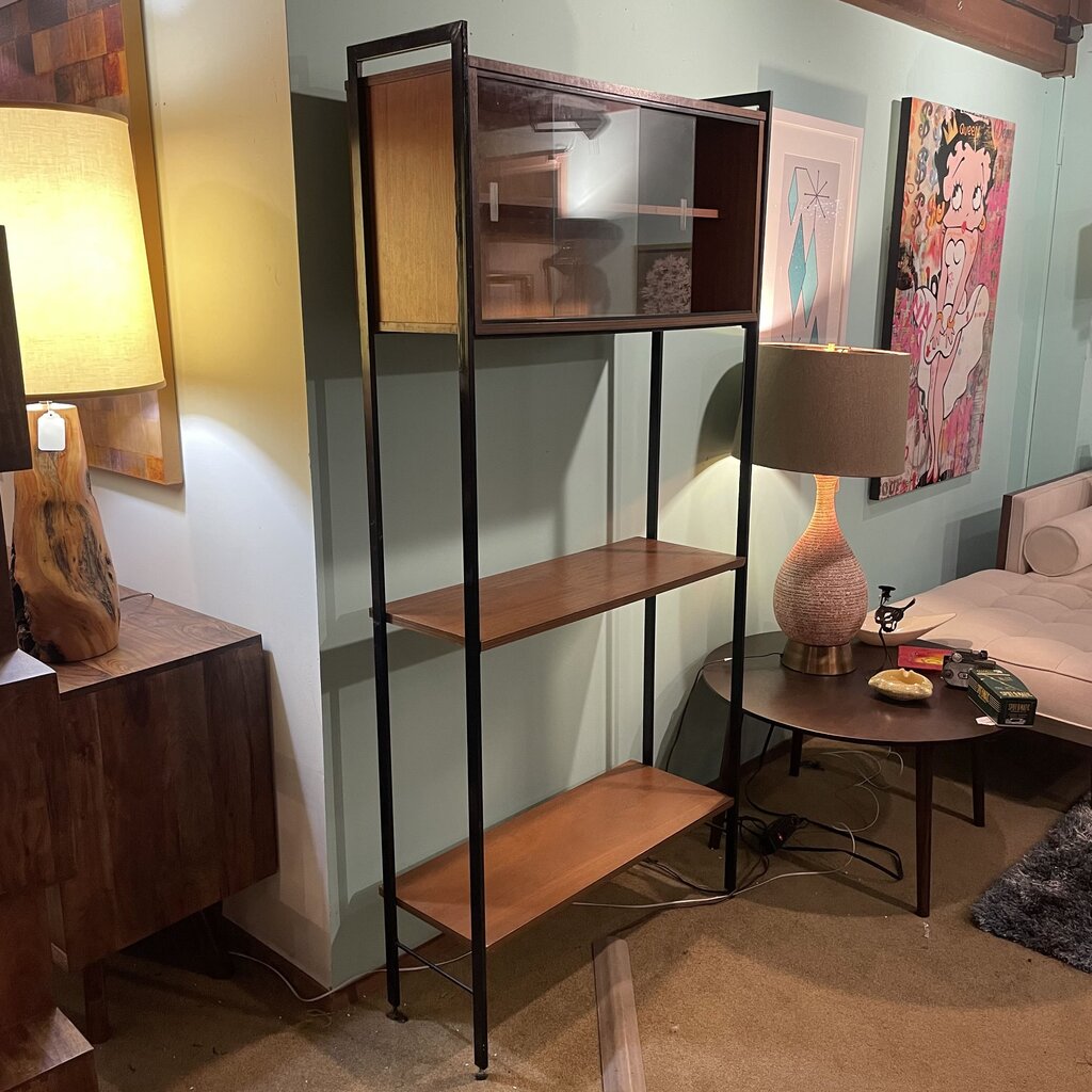 This mid-century modern (MCM) bookshelf features a balanced combination of open display and protected storage. The unit features a minimalist black metal frame that creates a tall, slender silhouette.