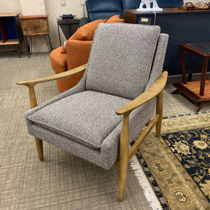Gray armchair with wooden arms and legs in a room setting