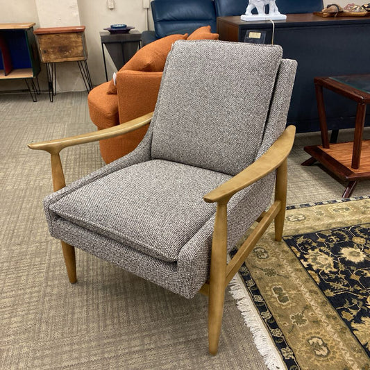 Gray armchair with wooden arms and legs in a room setting