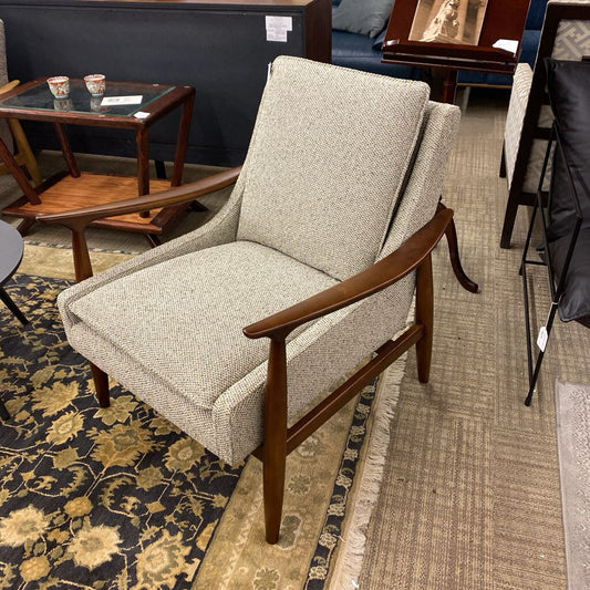 Gray upholstered chair with wooden arms in a showroom setting