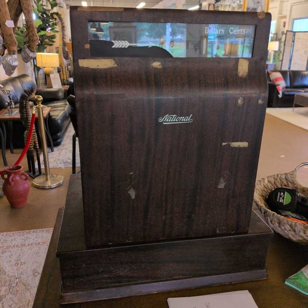 Vintage cash register with 'National' branding on a wooden surface.