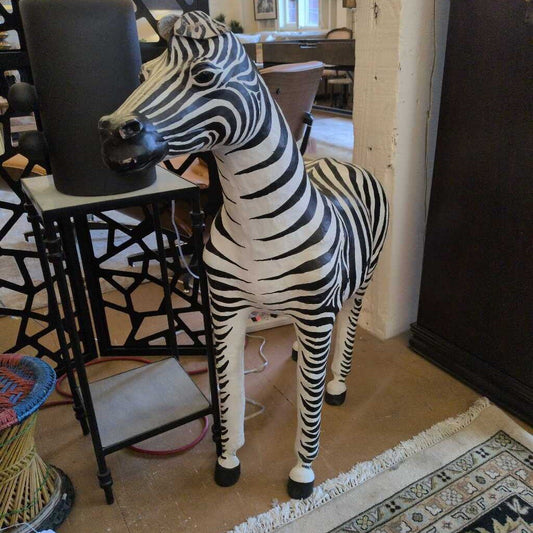 Zebra statue in a room with furniture and decor