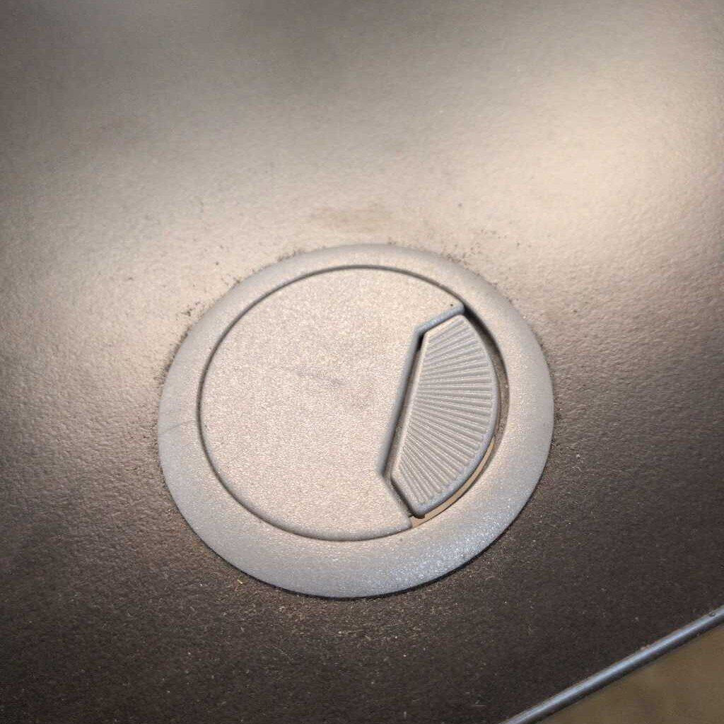 Close-up of a metallic surface with a circular indentation and slotted detail.