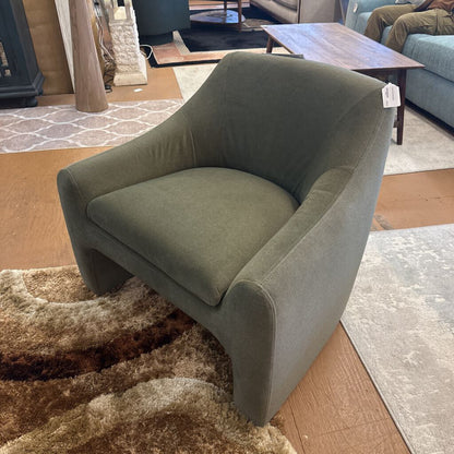 Green armchair in a room with a rug and furniture