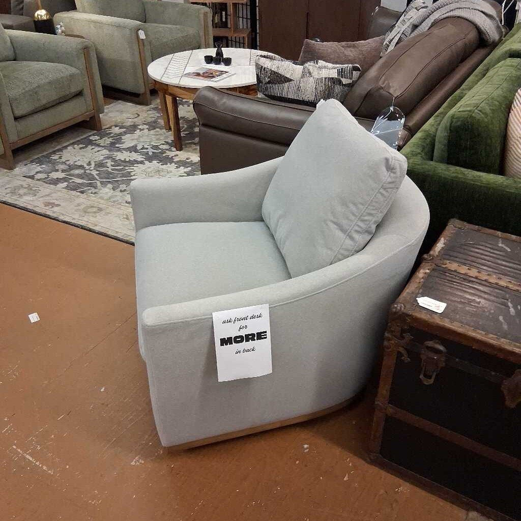 Gray armchair with a sign in a furniture store setting