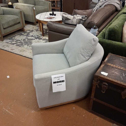 Gray armchair with a sign in a furniture store setting