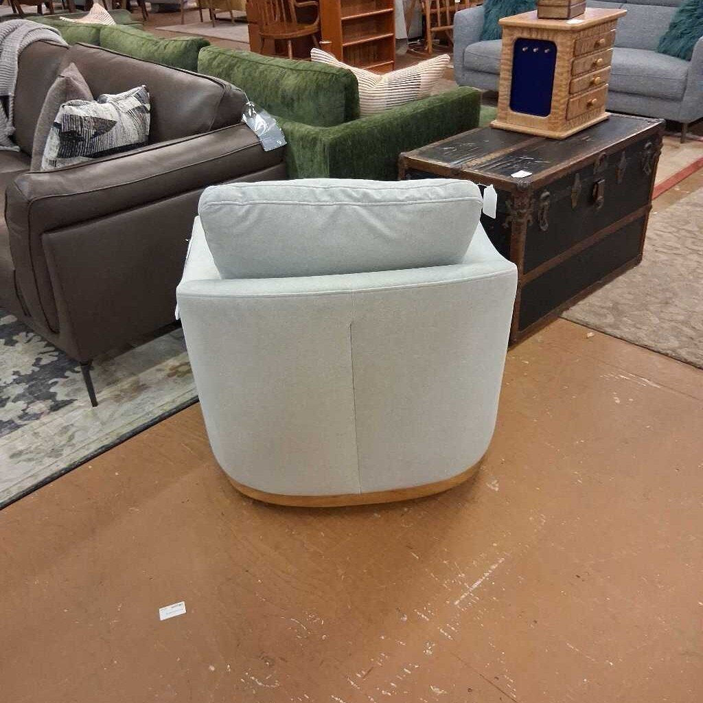 White armchair in a room with brown floor and furniture