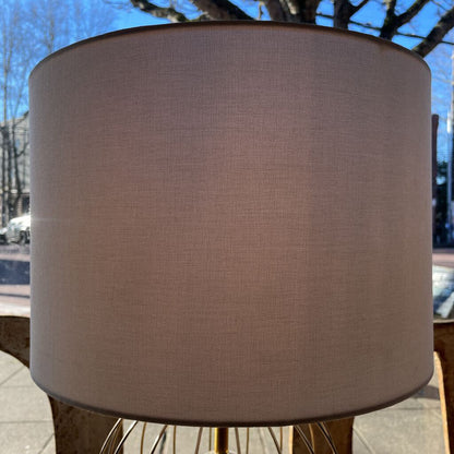 Brown lampshade on a stand with a blurred outdoor background