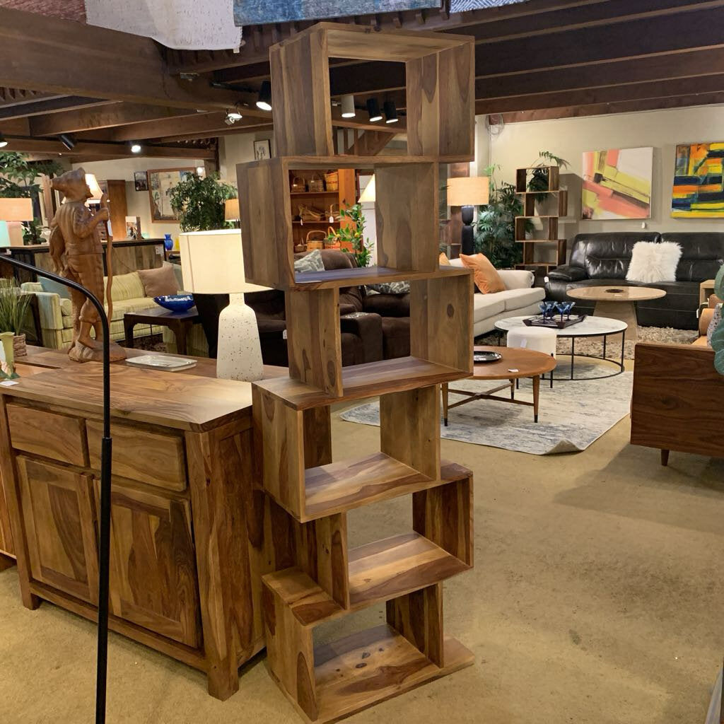 Wooden furniture pieces including a bookshelf and desk in a living room setting.
