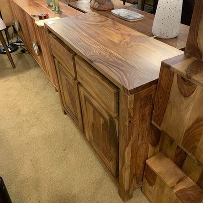 Wooden bar counter with a marble-like top in a room setting.