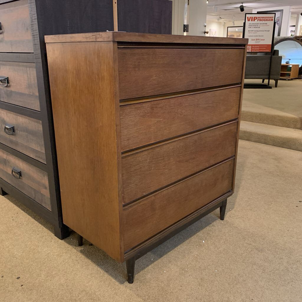 Wooden dresser with multiple drawers in a showroom setting