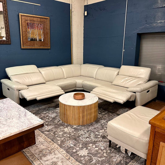 White sectional sofa in a living room with a coffee table and rug.