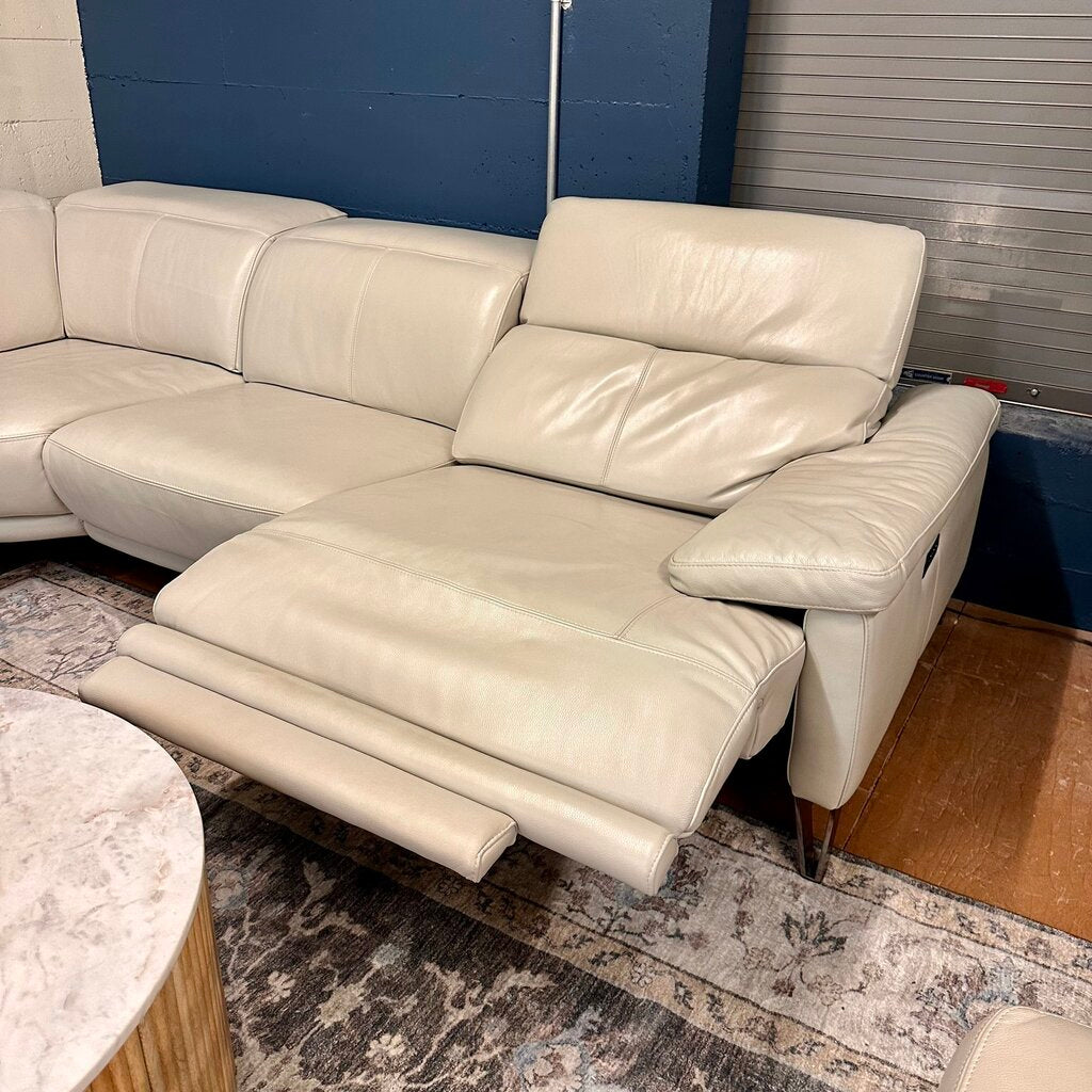 Beige sectional sofa in a room with a blue wall and wooden floor.