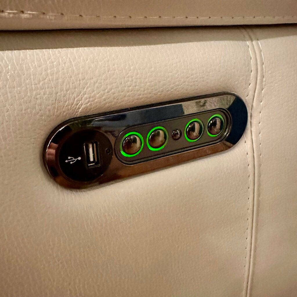 Car interior USB port and control panel with green indicator lights on beige leather.