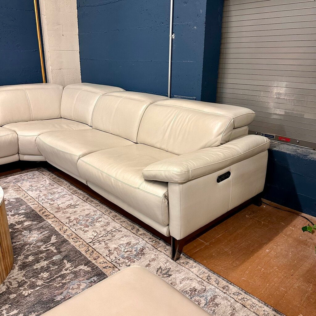 Beige sectional sofa in a room with a patterned rug and blue walls.