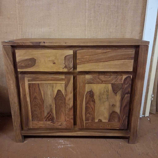 Wooden sideboard with natural grain pattern against a plain wall.