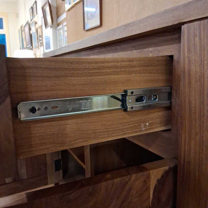 Wooden drawer with metal slide mechanism in a home setting