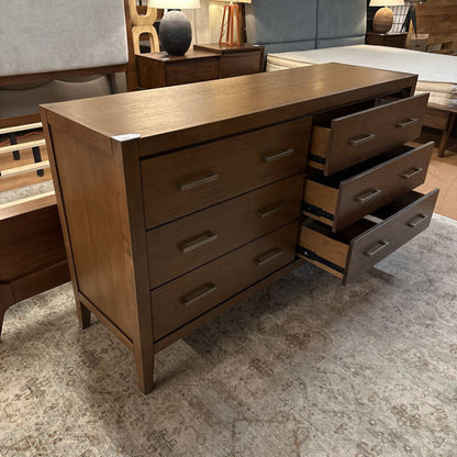 Wooden dresser with open drawer in a bedroom setting