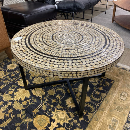 Round mosaic coffee table with decorative pattern on a floral rug
