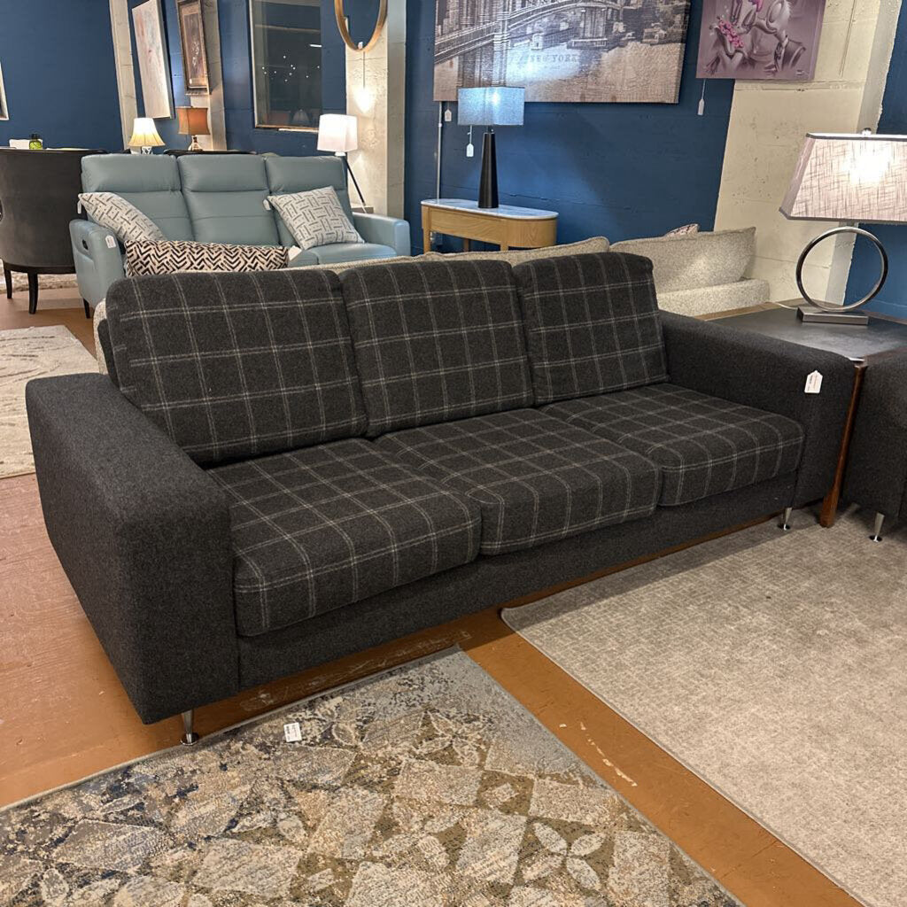 Gray plaid sofa in a living room setting with other furniture and decor.