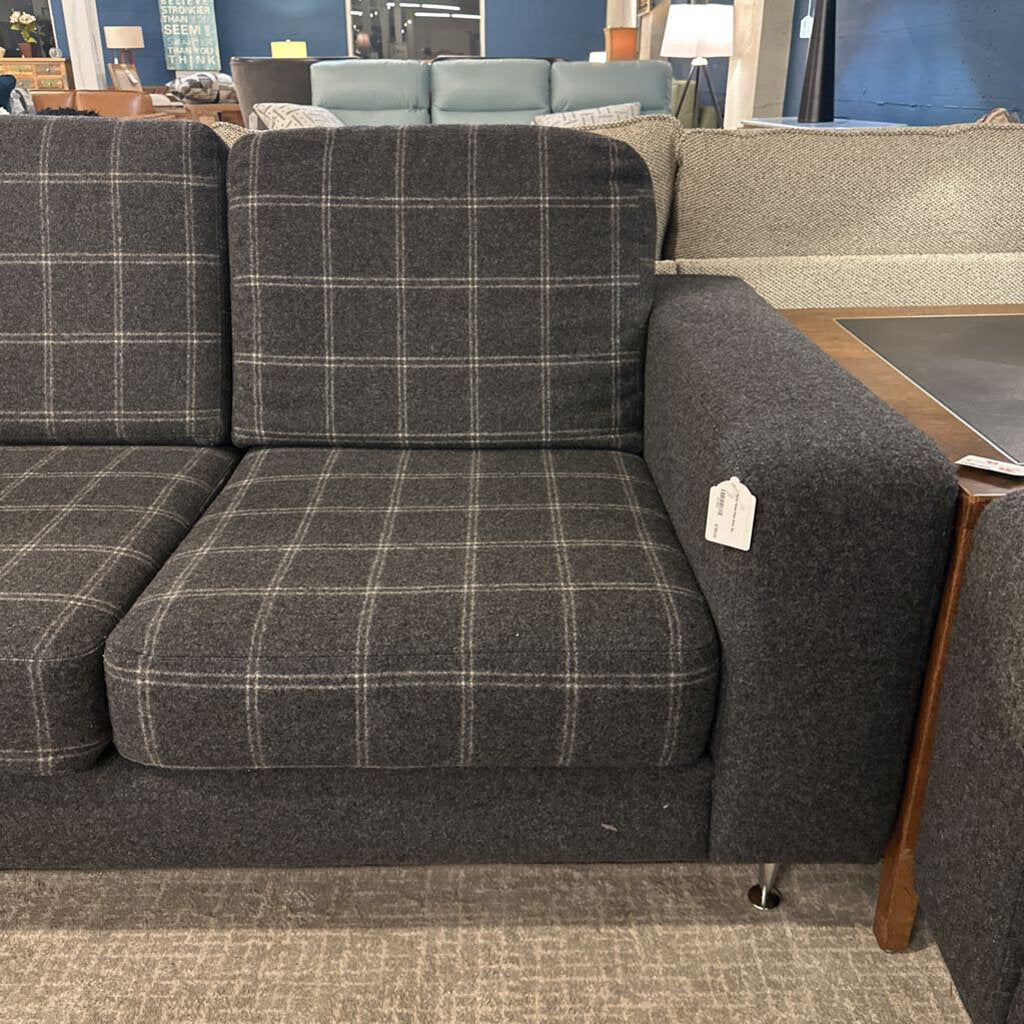 Gray checkered sofa with a price tag in a store setting