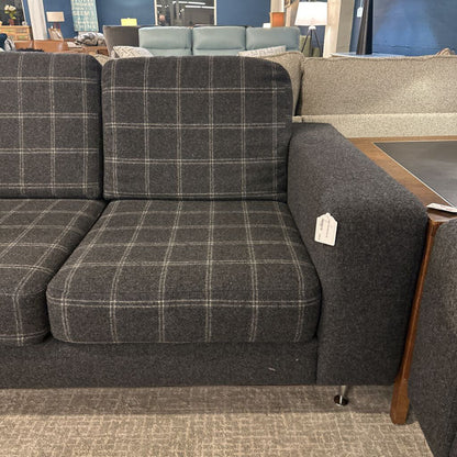 Gray checkered sofa with a price tag in a store setting