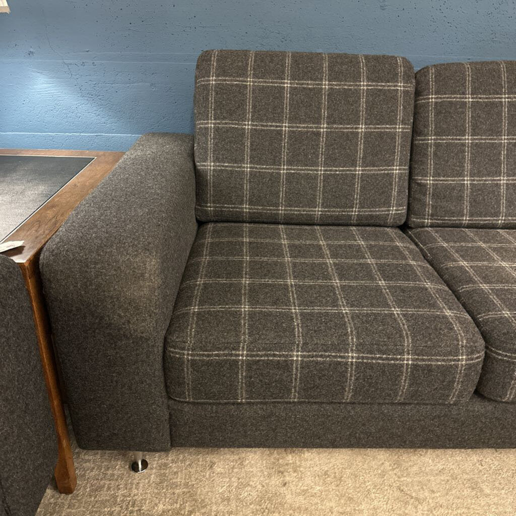 Gray checkered sofa against a blue wall.