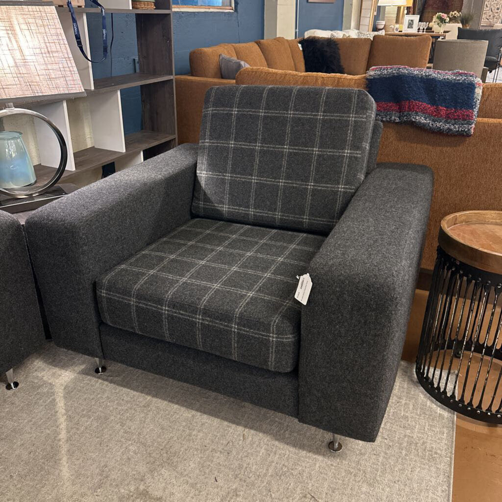 Gray checkered armchair in a showroom setting with other furniture.