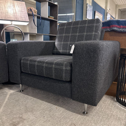 Gray checkered armchair in a store setting with a price tag.