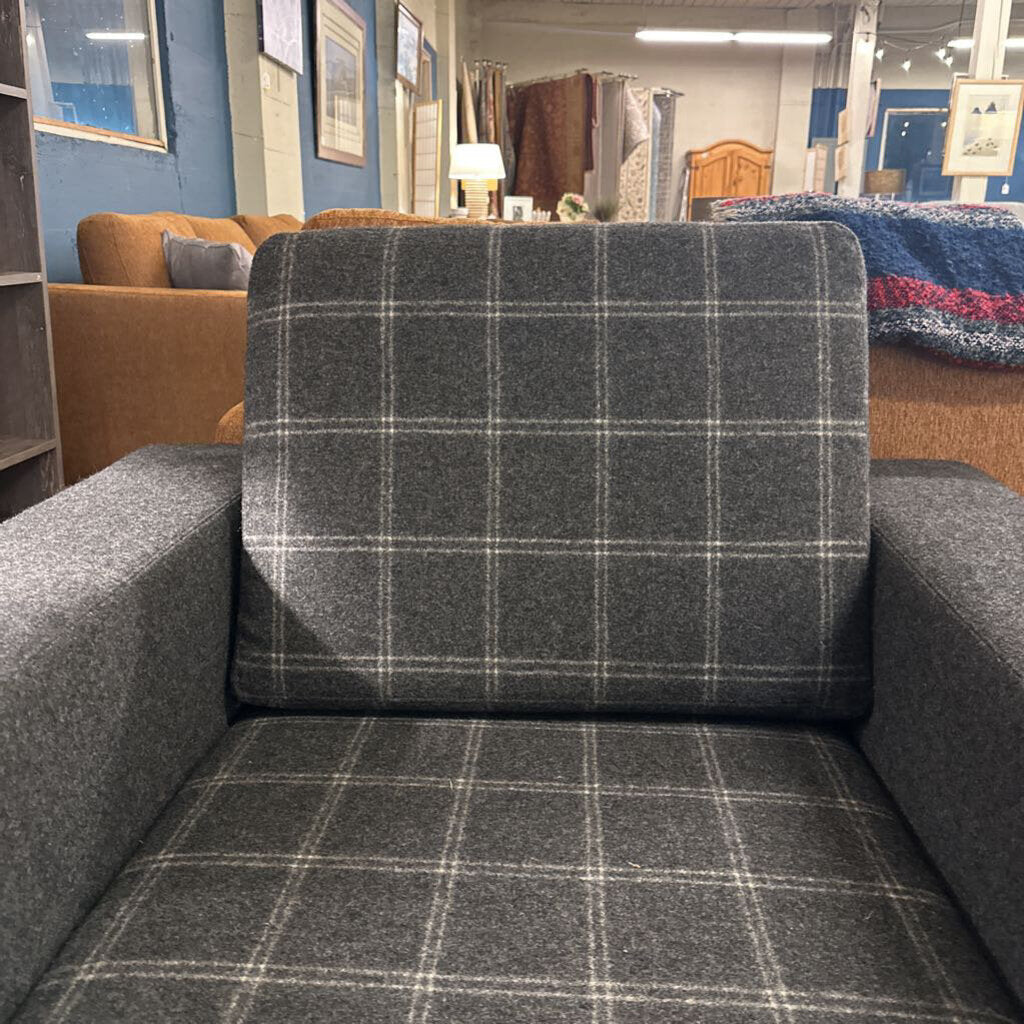Gray checkered sofa in a showroom setting with other furniture.