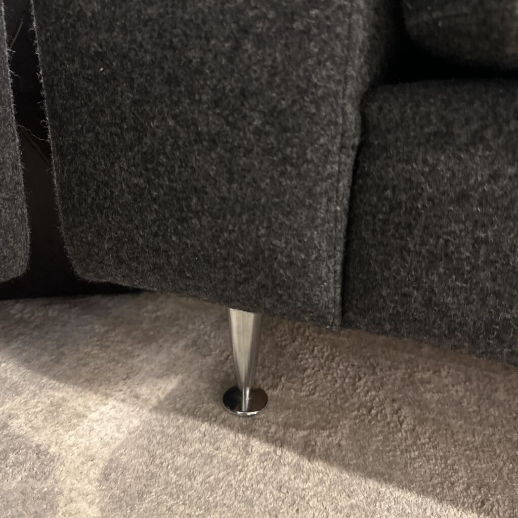Close-up of a gray sofa leg on a carpeted floor
