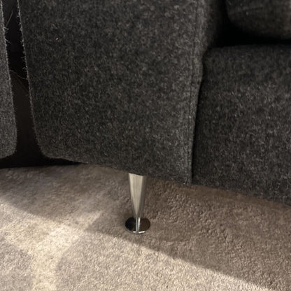 Close-up of a gray sofa leg on a carpeted floor