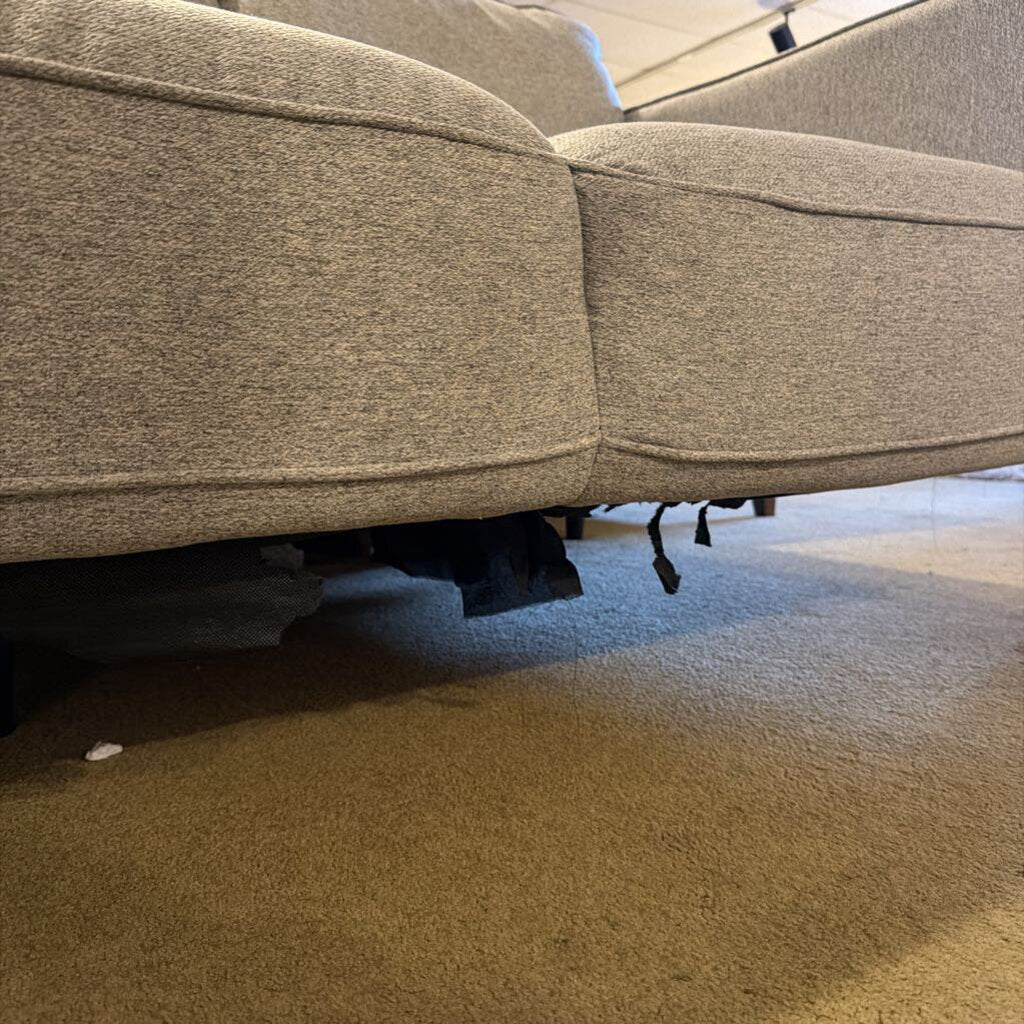 Close-up of a gray upholstered chair on a carpeted floor