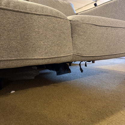 Close-up of a gray upholstered chair on a carpeted floor