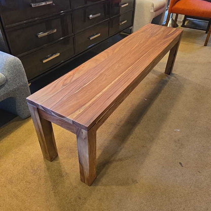 A long, rectangular solid wood bench with a waterfall-style top and thick, square legs, showcasing a vibrant natural wood grain.
