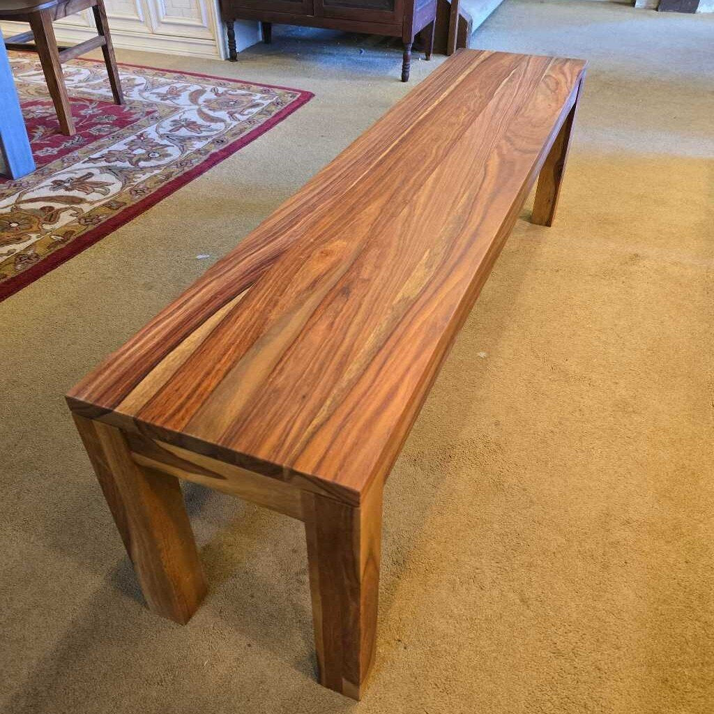 A long, rectangular solid wood bench with a waterfall-style top and thick, square legs, showcasing a vibrant natural wood grain.
