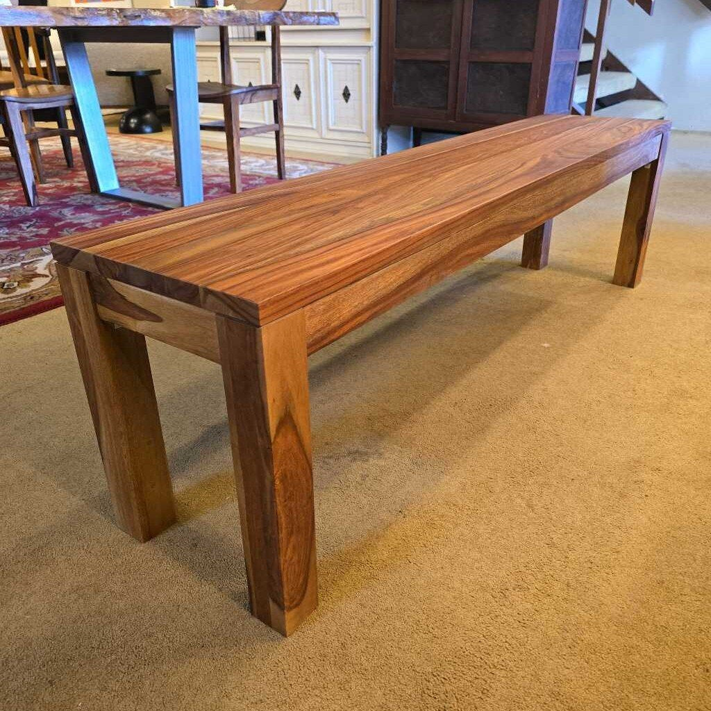 A long, rectangular solid wood bench with a waterfall-style top and thick, square legs, showcasing a vibrant natural wood grain.