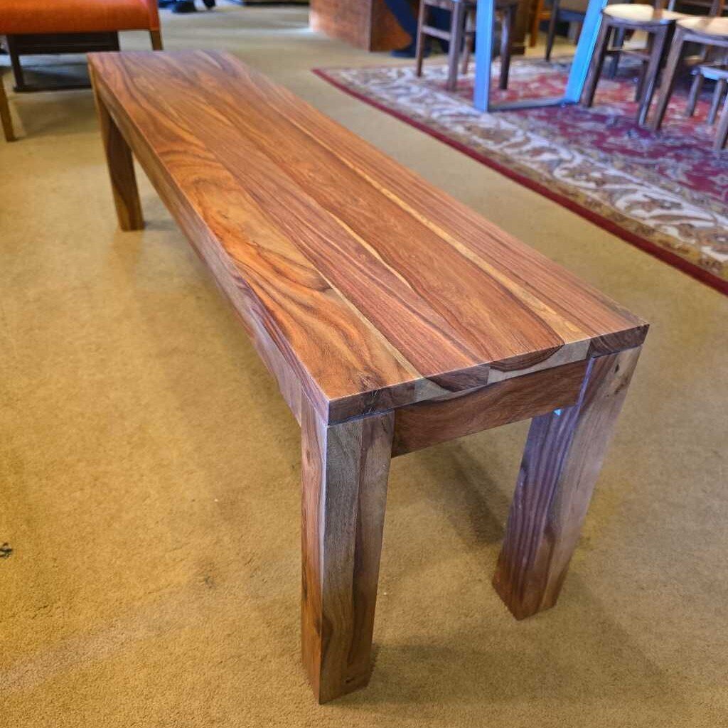 A long, rectangular solid wood bench with a waterfall-style top and thick, square legs, showcasing a vibrant natural wood grain.