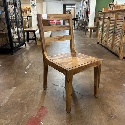 Wooden chair in a store setting with other furniture items.