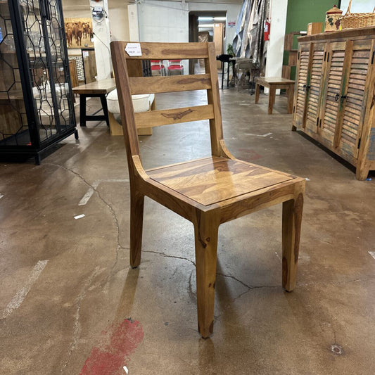 Wooden chair in a store setting with other furniture items.